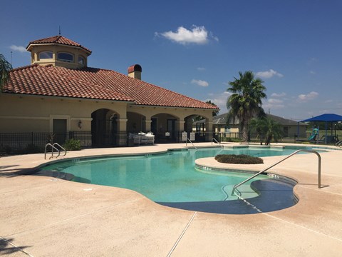 A pool with a building behind it.