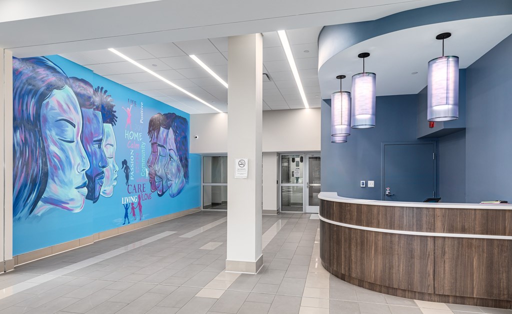 A reception area with a large mural on the wall.