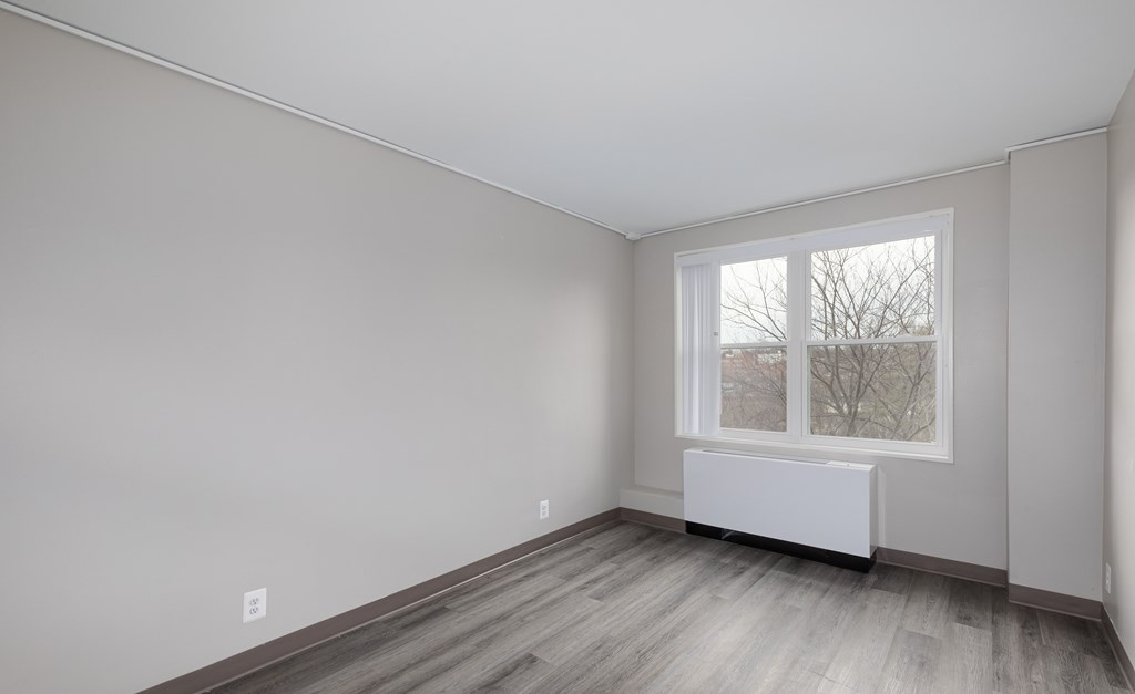 A room with a window and a radiator on the wall.