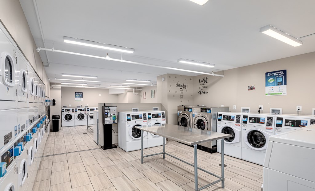 A laundromat with rows of washing machines and a sign that says "With Clean".