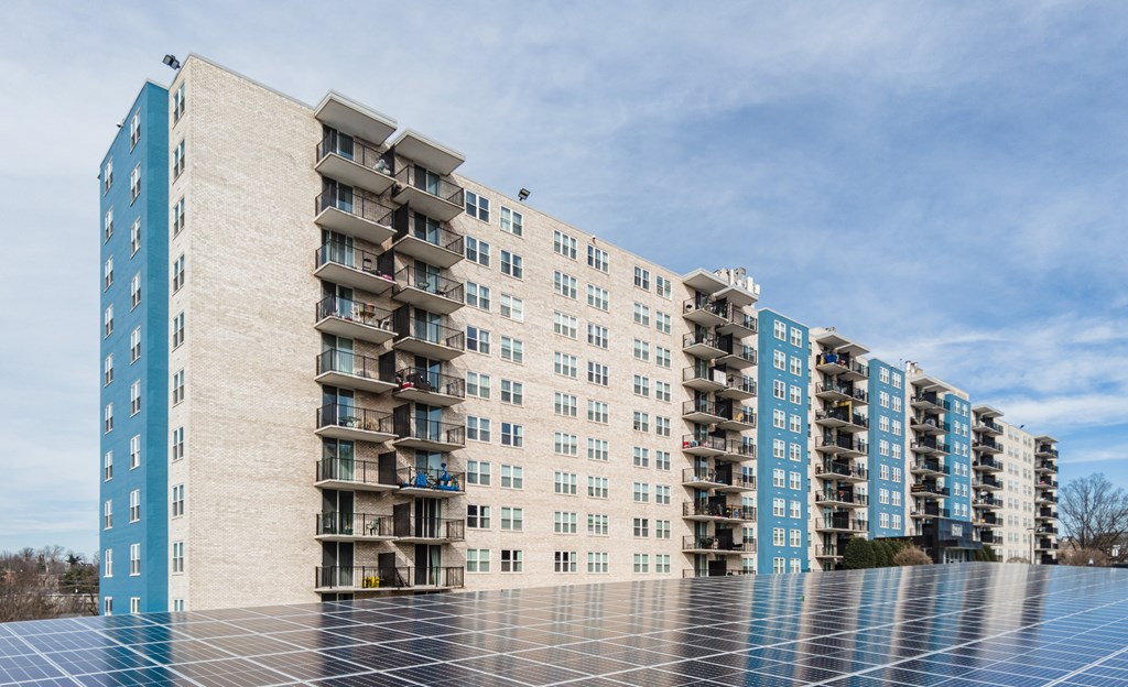 A row of modern apartment buildings with solar panels on the roof.