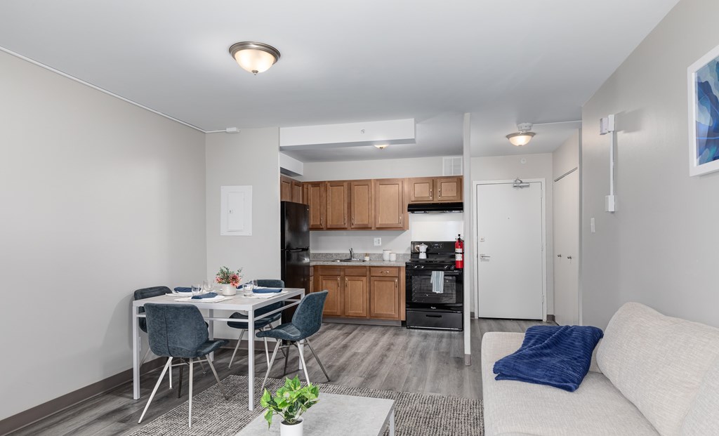 A kitchen with a dining table and chairs is visible.