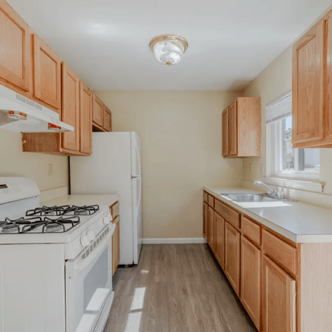 A kitchen with wooden cabinets and white appliances.