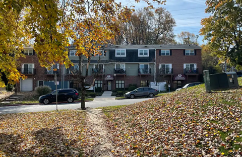 A residential area with houses and cars parked on the street.