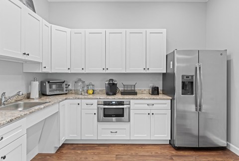 A kitchen with white cabinets and stainless steel appliances.