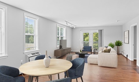 A living room with a round table and blue chairs.