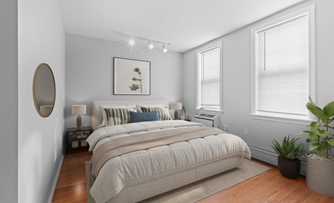 A bedroom with a large bed and a potted plant.