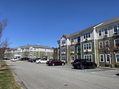 A parking lot with cars and apartment buildings in the background.