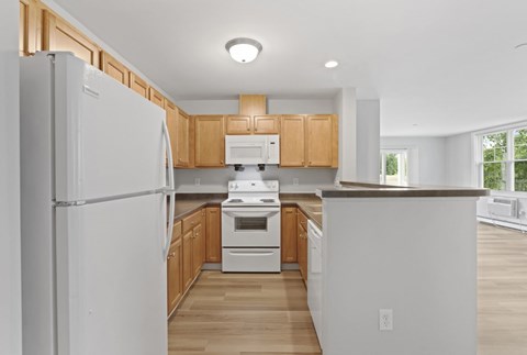 A kitchen with wooden cabinets and a white refrigerator.
