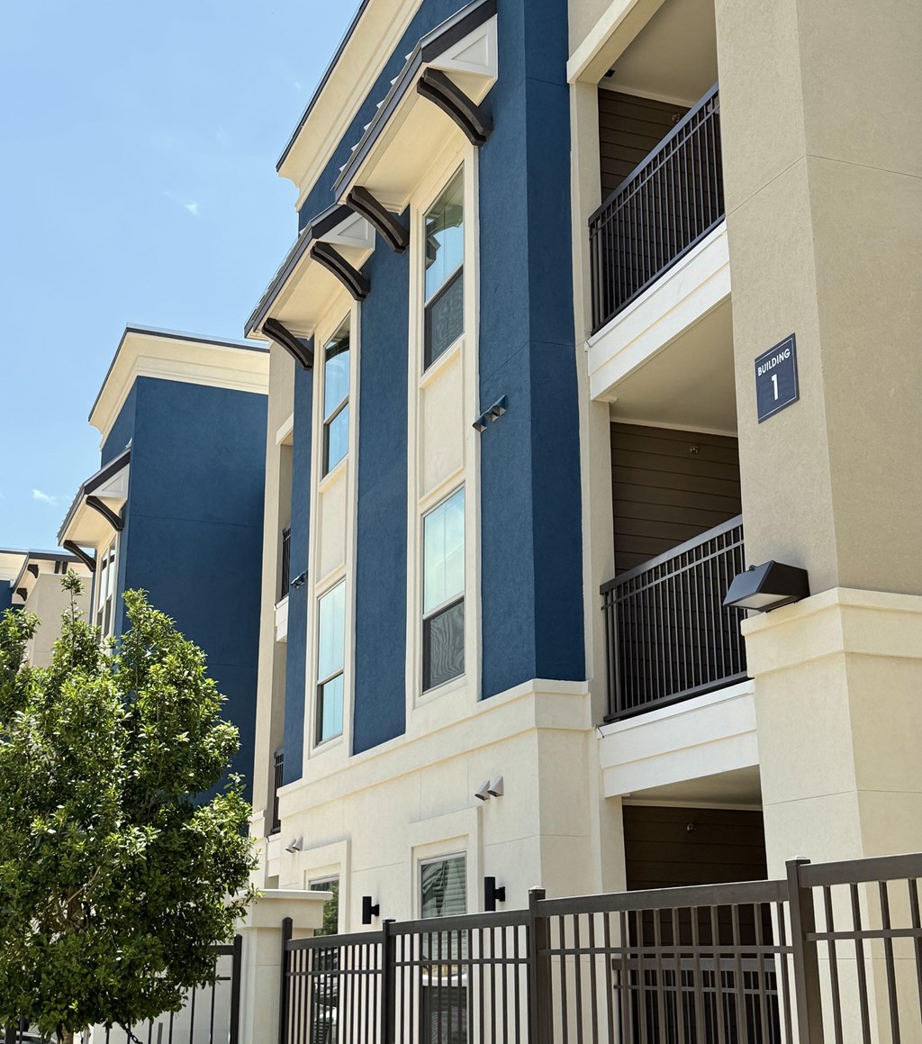 A blue and white building with a black gate in front.