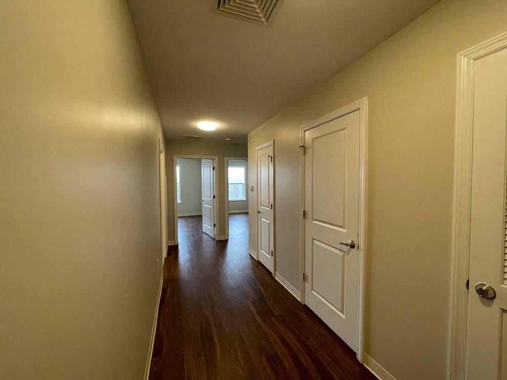 a hallway with white doors and a wood floor