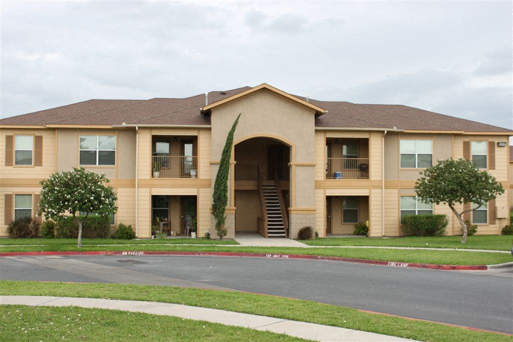 the front of an apartment building with a sidewalk