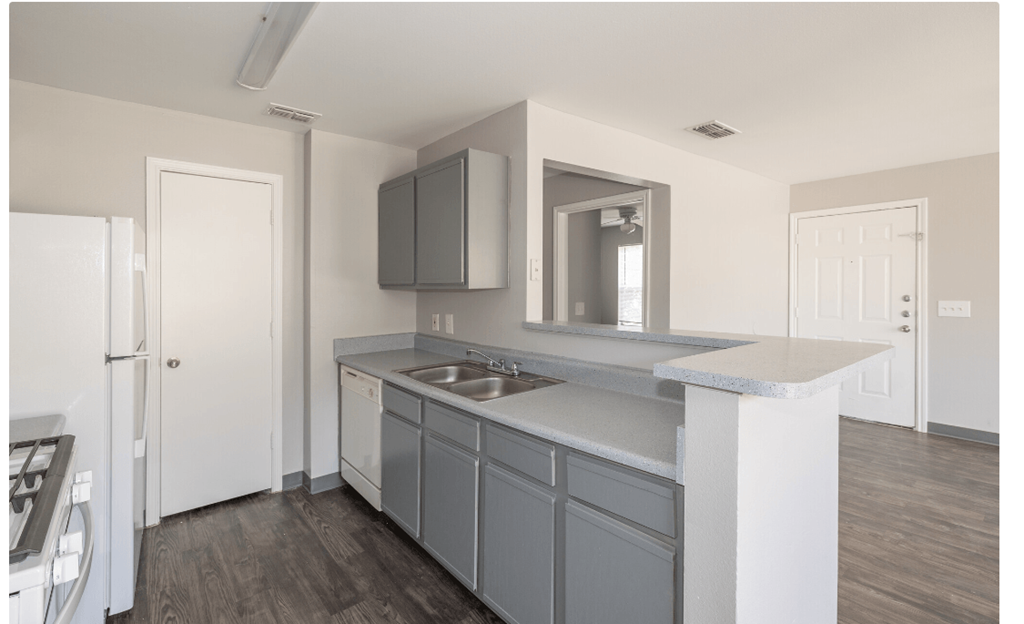 an empty kitchen with a sink and a white refrigerator