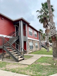 a red house with stairs and a palm tree