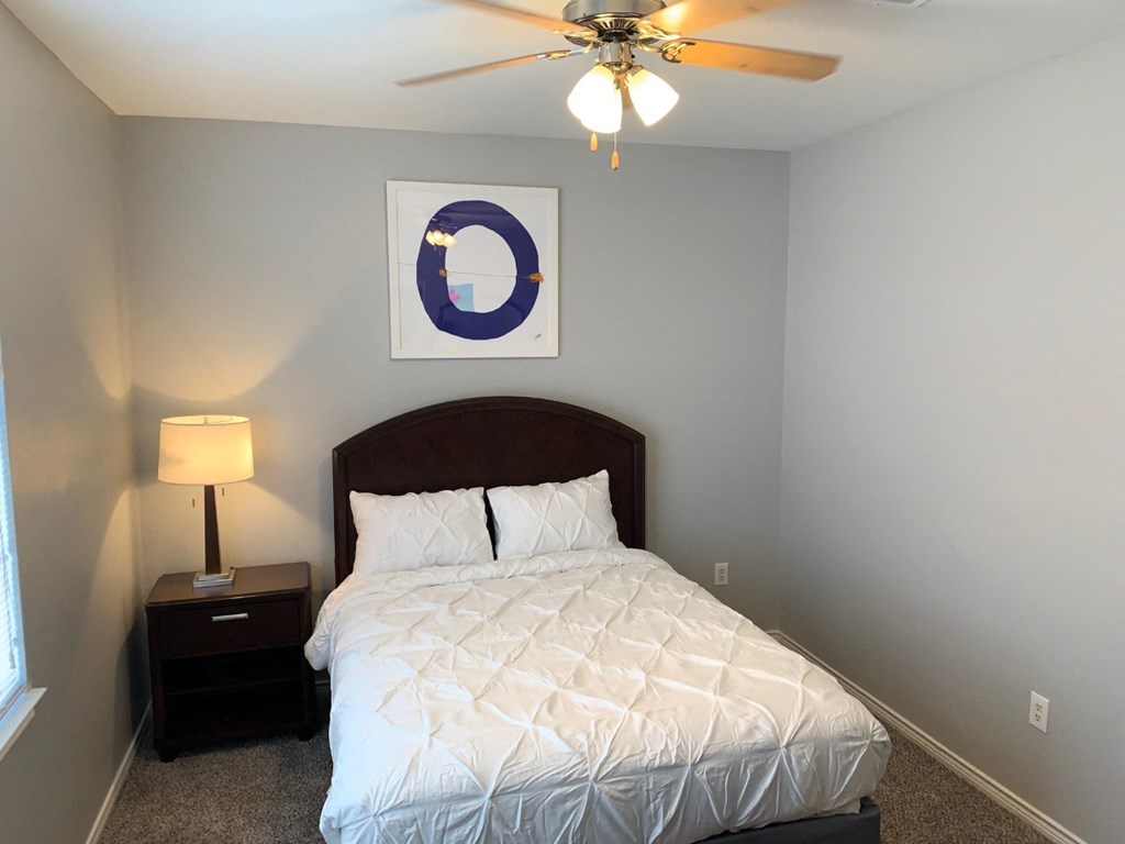 a bedroom with a bed and a ceiling fan