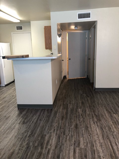 A kitchen with a white counter and a refrigerator.