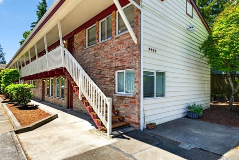 A white house with a red brick staircase.