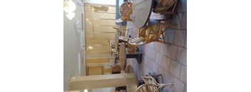 A row of wooden chairs are stacked on top of each other.