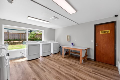 Horizon Park Shared Laundry with white washer and dryers and wooden floors