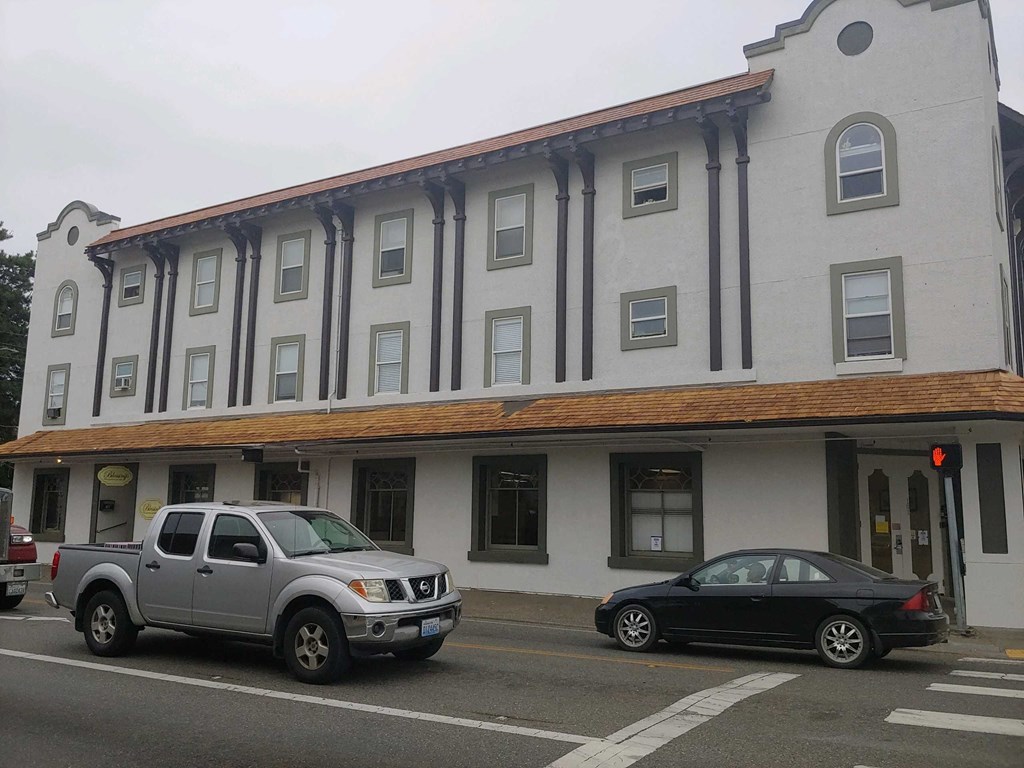 a building with a brown and white facade and a black car parked in front of it