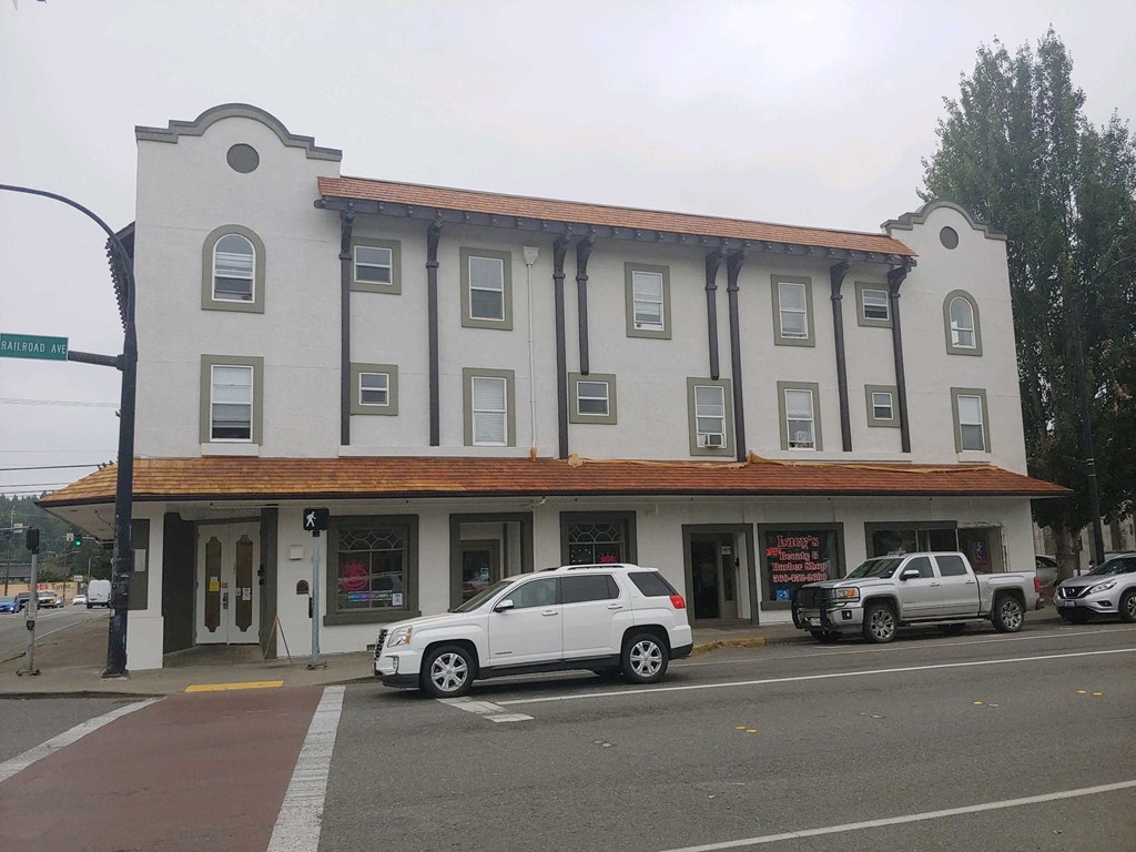 a building on the corner of a street with cars parked in front of it