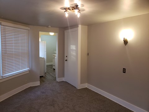 a bedroom with a ceiling fan and a door to a bathroom