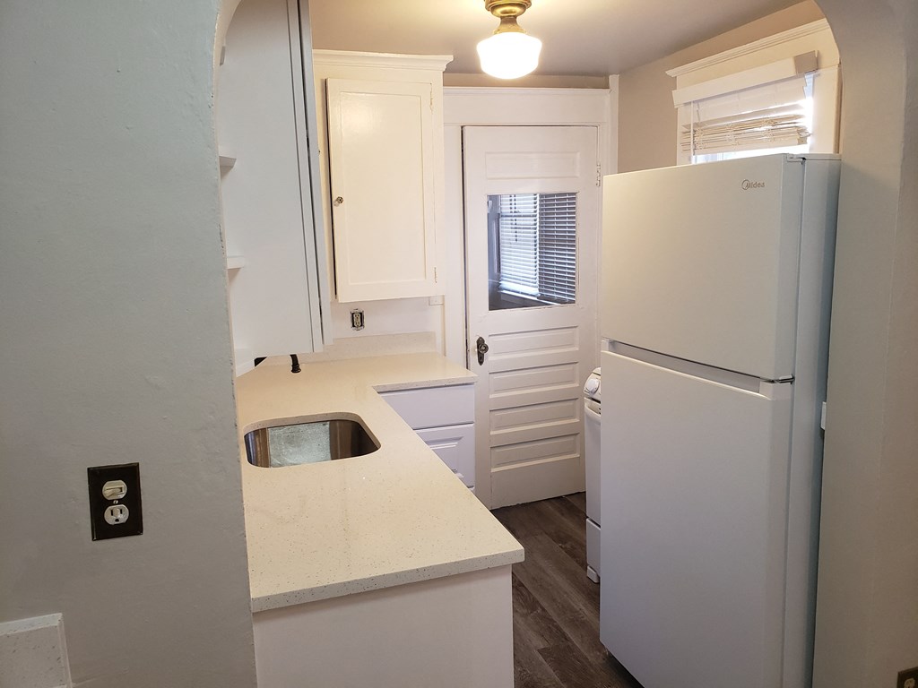 a small kitchen with a refrigerator and a sink