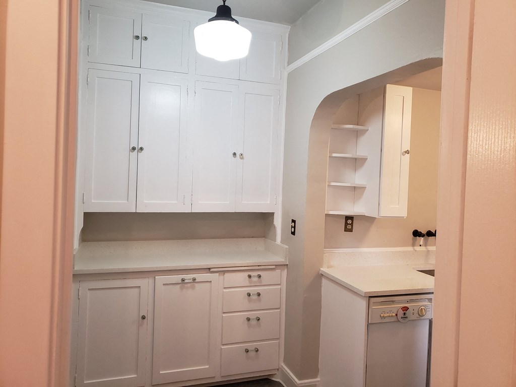 a kitchen with white cabinets and a sink and a counter