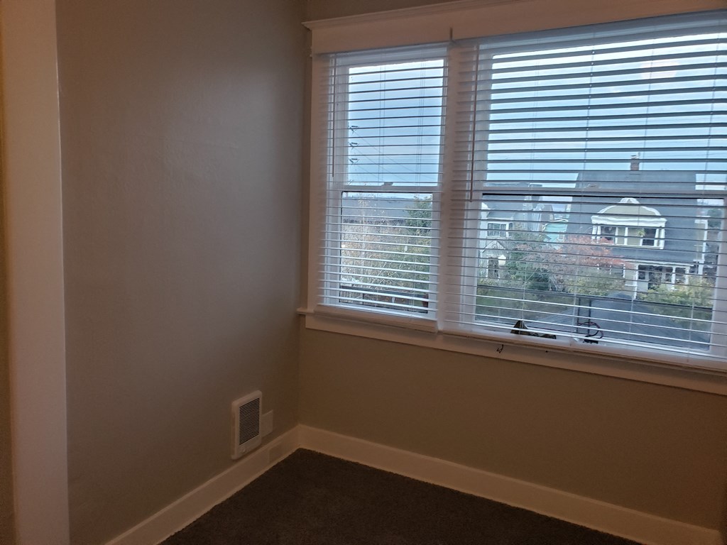 an empty room with a window with blinds