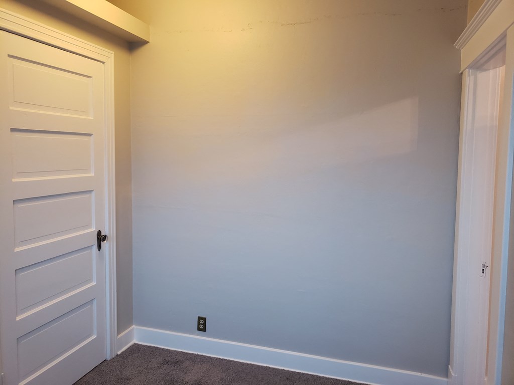 an empty room with blue walls and a white door