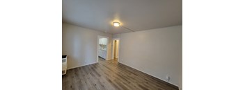 A room with wooden flooring and white walls.