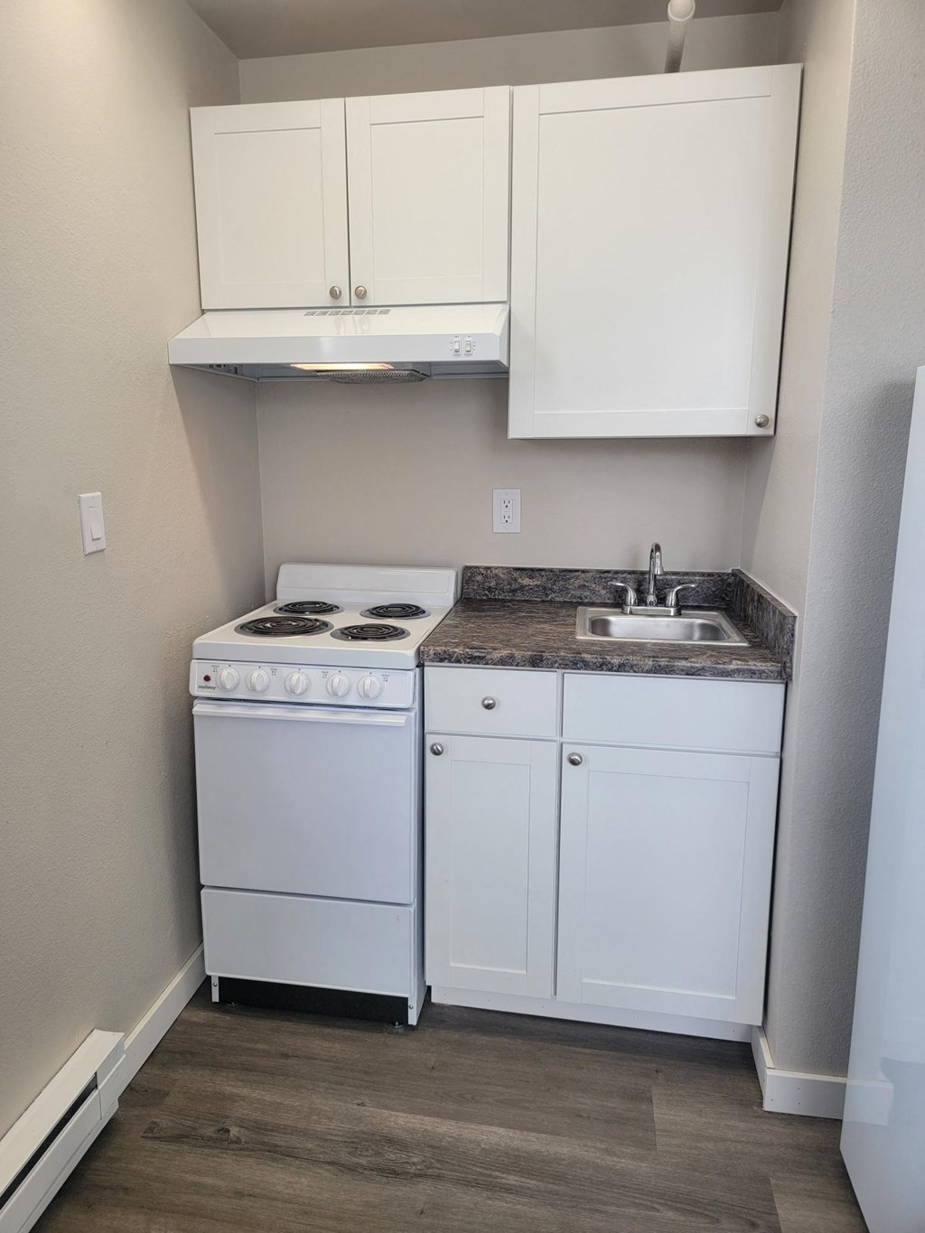 a small kitchen with a stove sink and cupboards