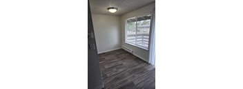 A room with a window and a grey floor.
