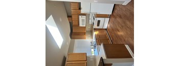 A modern kitchen with wooden cabinets and a skylight.