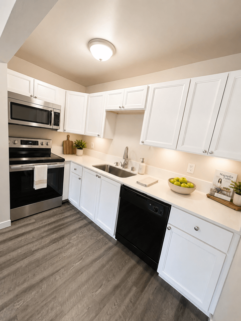 A modern kitchen with white cabinets and a black dishwasher.