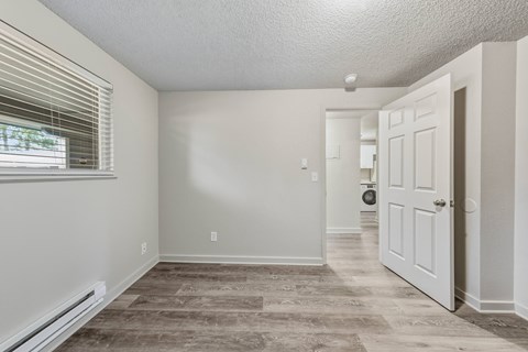 A room with a carpeted floor and a white door.