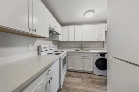 A kitchen with white cabinets and appliances.