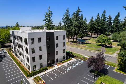 A large white building with a parking lot in front.