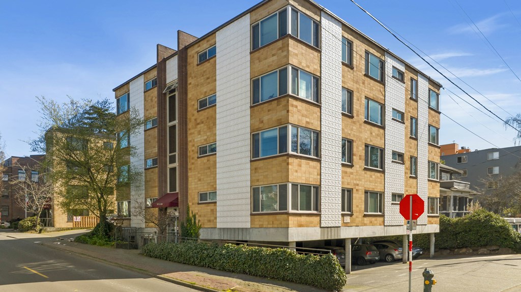 an apartment building on a street corner with a stop sign