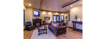 A living room with a brown leather couch and a fireplace.