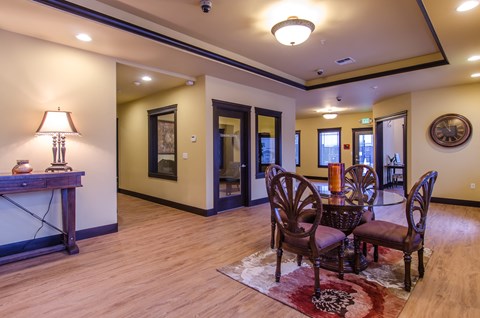 A living room with a fireplace and a table with chairs.