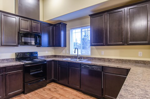 A kitchen with dark wood cabinets and appliances.