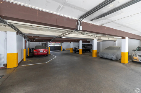 A parking garage with a red car in the center.