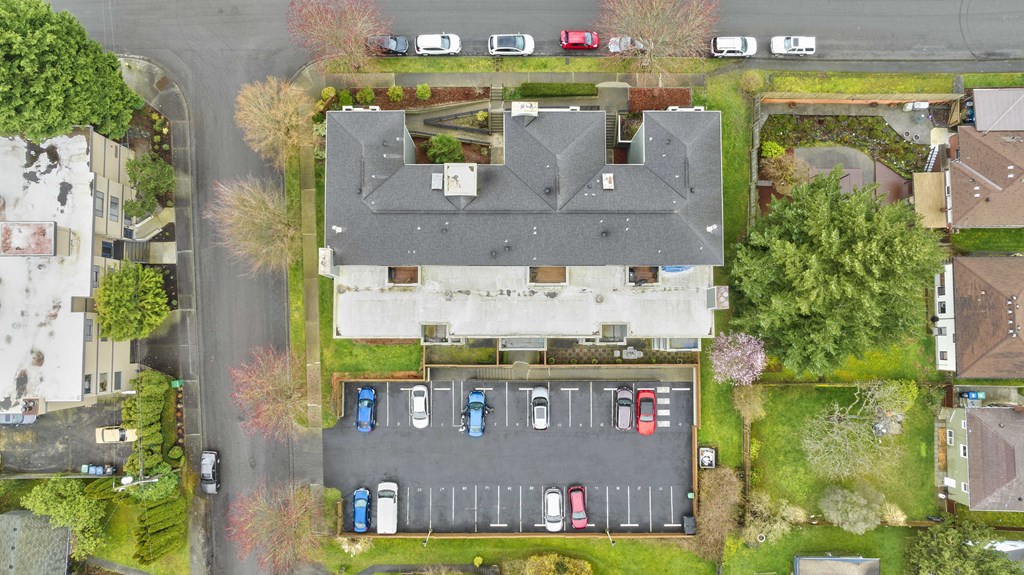 a birdseye view of a house and parking lot from above