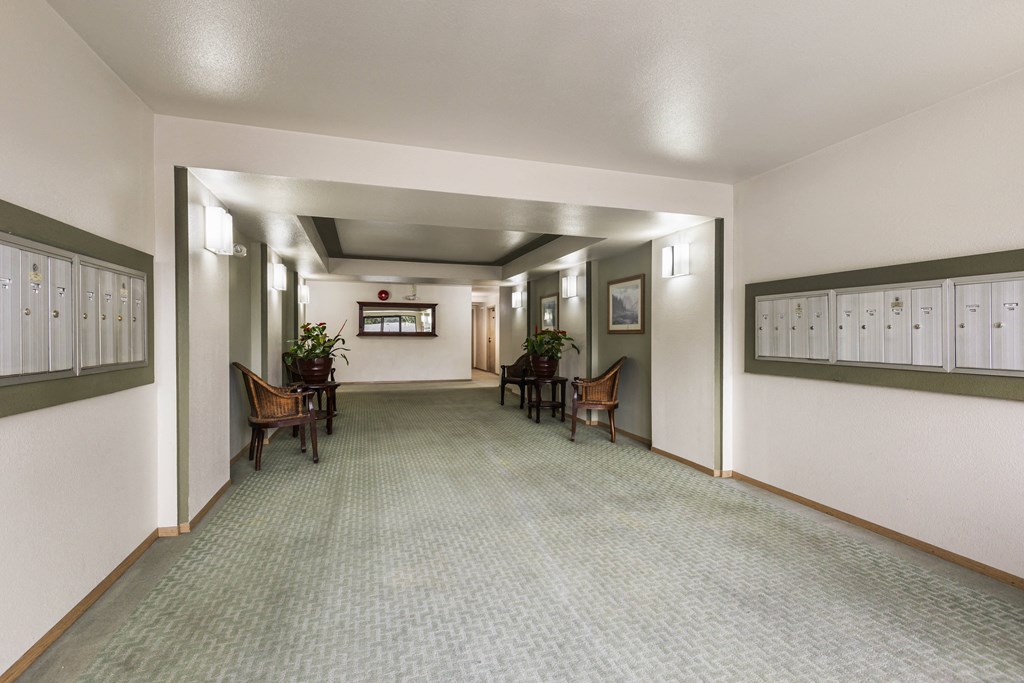 a hallway with chairs and tables and lockers on the wall
