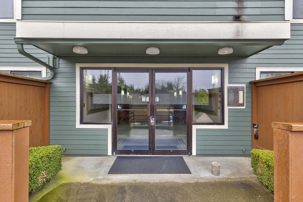 the front entrance of a house with glass doors and a patio