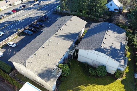 Aerial view of Bridgeport Terrace Apartments with black roof and white and tan painted siding.