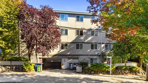 A building with a garage door and a sign that says "No Parking" in front of it.
