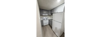 A white refrigerator is in a kitchen with white appliances.