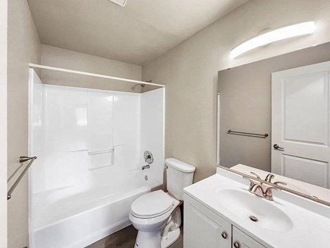 A white bathroom with a toilet, sink, and shower.